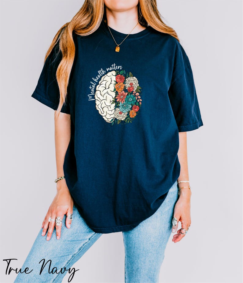 a woman wearing a blue t - shirt with a flowered brain on it