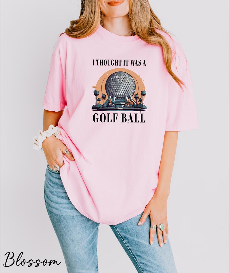 a woman wearing a pink shirt that says i thought it was a golf ball