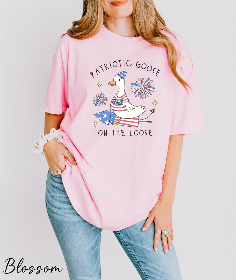 a woman wearing a pink patriotic goose t - shirt