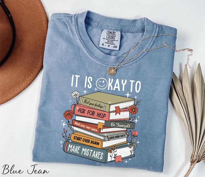 a blue tshirt with a stack of books on it