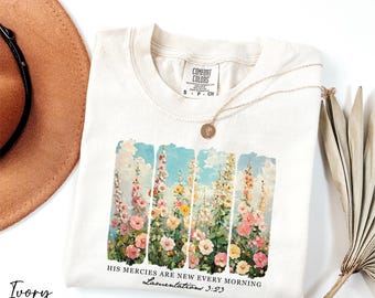 Puede incluir: Camiseta de color marfil con estampado floral y el texto "Sus misericordias son nuevas cada mañana. Lamentaciones 3:23".