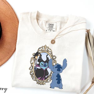 A white t-shirt with a graphic design featuring a character from the Disney animated film Lilo and Stitch, standing in front of a mirror.