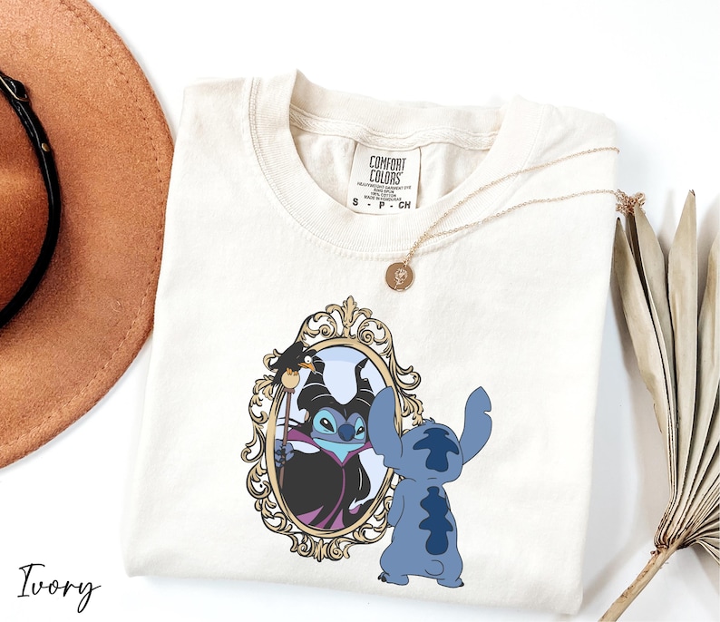 A white t-shirt with a graphic design featuring a character from the Disney animated film Lilo and Stitch, standing in front of a mirror.