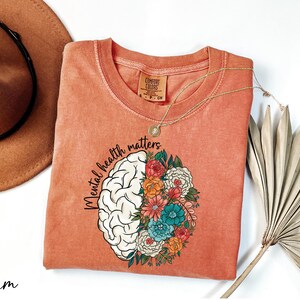 a t - shirt with a picture of a brain and flowers on it