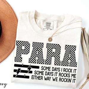 a white t-shirt with a black and white checkered design, along with a brown hat and a plant.