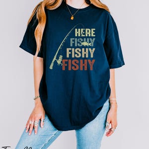 a woman wearing a t - shirt that says here fishy fishy