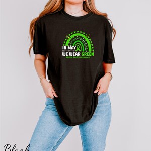 a woman wearing a black t - shirt with a green design