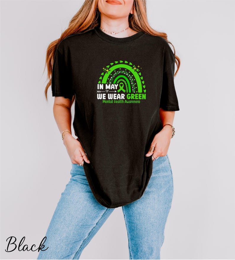 a woman wearing a black t - shirt with a green design
