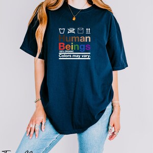a woman wearing a t - shirt that says human beings colors may vary