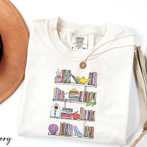 a hat, sunglasses, and a t - shirt with a picture of a book