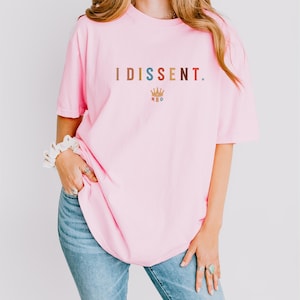 a woman wearing a pink t - shirt and jeans