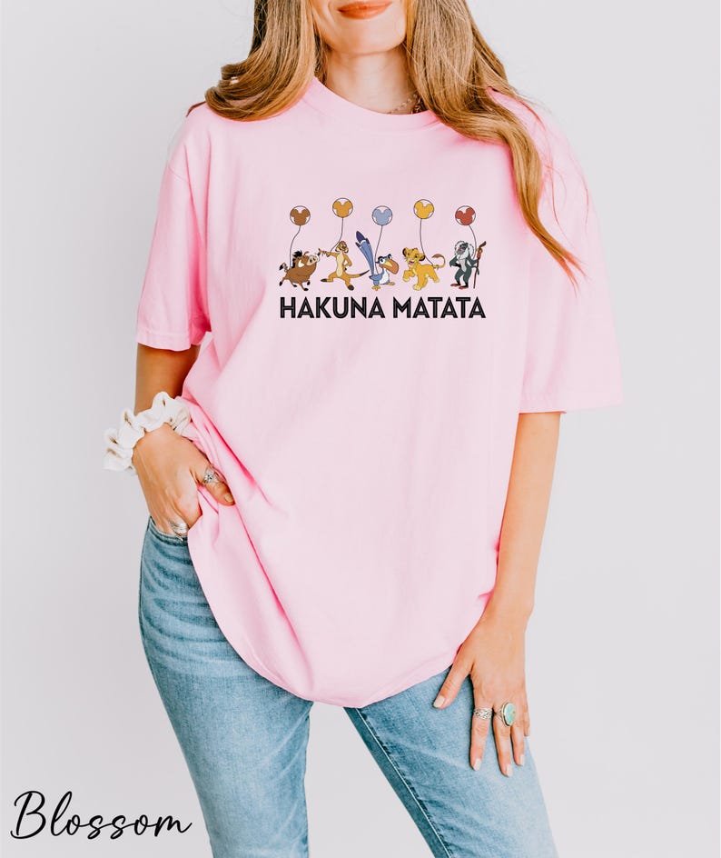 a woman wearing a pink shirt that says hakuna matata