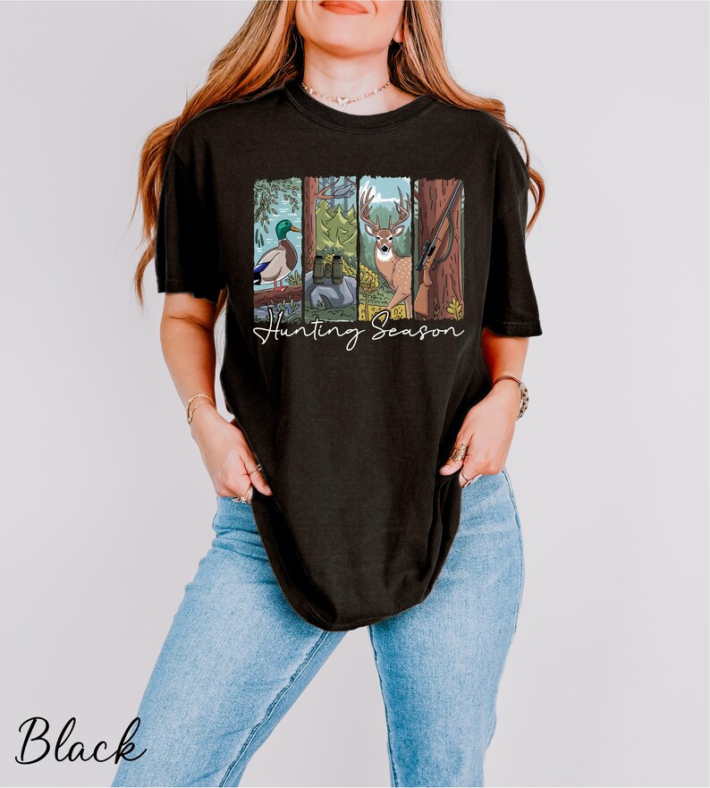 A woman wearing a black t-shirt with a graphic design depicting various hunting animals, including a deer, duck, and bear, along with the text "Hunting Season".
