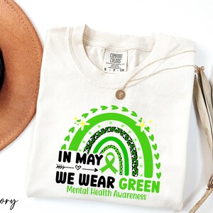 a hat, sunglasses, and t - shirt on a white surface