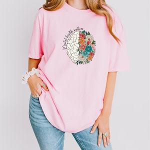 a woman wearing a pink shirt and jeans