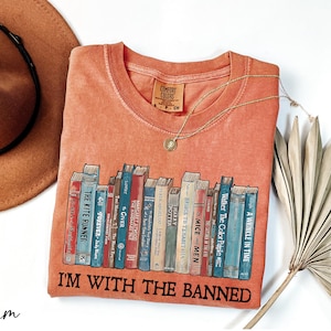 a t - shirt that says i'm with the banned on it next to