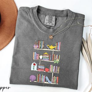 a t - shirt with a picture of a bookshelf on it