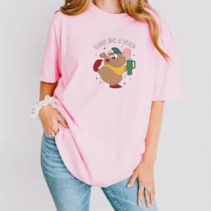 a woman wearing a pink shirt with a cartoon character on it