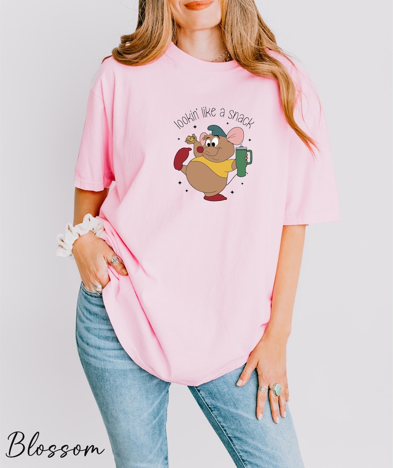 a woman wearing a pink shirt with a cartoon character on it