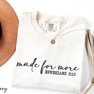 a hat, sunglasses, and t - shirt on a white surface