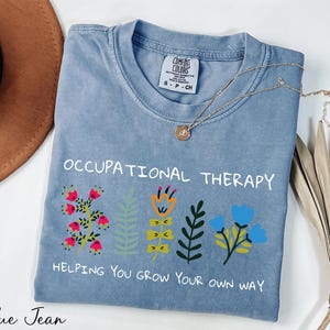 a blue t - shirt with embroidered words on it