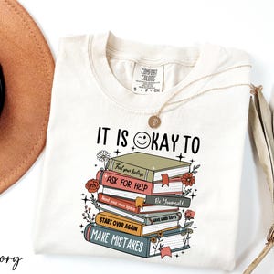 a white shirt with a stack of books on it