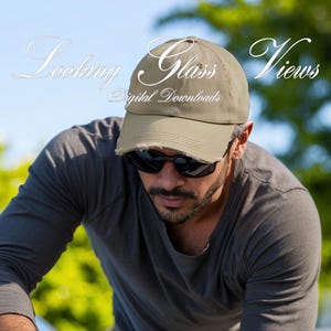 May include: A man wearing a khaki baseball cap with the text "Glass Views Digital Downloads" on the front. He is wearing sunglasses and a gray t-shirt.