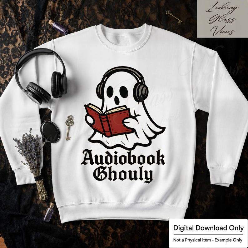 Pode incluir: Camisola branca com um fantasma de desenho animado usando fones de ouvido e lendo um livro vermelho. O texto "Audiobook Ghouly" est&aacute; impresso abaixo do fantasma. Um design divertido para amantes de livros e do Halloween.