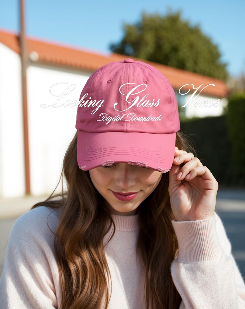May include: A pink distressed baseball cap with the text "Looking Glass Views Digital Downloads" in white.