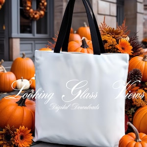 May include: White tote bag with black handles, surrounded by pumpkins and fall foliage. The bag has the text "Looking Glass Views Digital Downloads" printed on it.