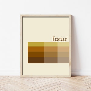 May include: A framed print with a beige background and a brown geometric design. The word "focus" is written in brown letters at the top of the design.