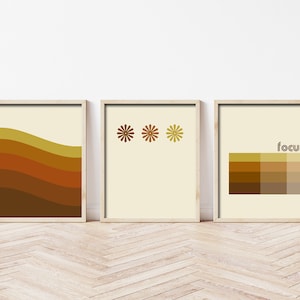 May include: Set of three abstract wall art prints in a retro style with brown, yellow, and cream colors. The prints feature geometric shapes and the word "focus" in a retro font.