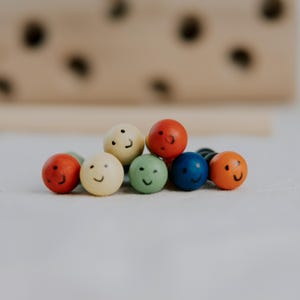 Set of colorful worm fidget toys on fabric background next to the wooden toy block.