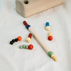 Scattered wooden worms and magnetic rod around Montessori toy, perfect for nursery play.