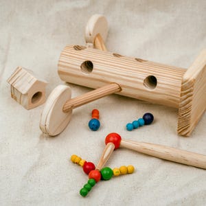 Wooden log magnetic worm catching toy with colorful worms and magnetic stick on neutral background