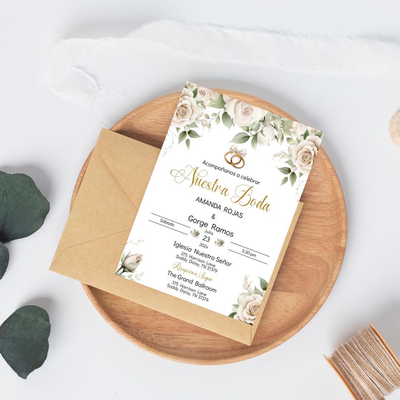 May include: A wedding invitation with white flowers and gold accents. The invitation reads "Acompa&ntilde;anos a celebrar Nuestra Boda Amanda Rojas & Gorge Ramos Sabado Julio 23 2022 3:30 pm Iglesia Nuestro Se&ntilde;or 375 Harrison Lane Soddy Daisy, TN 37379 Recepcion Seguir The Grand Ballroom 375 Harrison Lane Soddy Daisy, TN 37379"