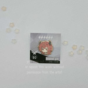 May include: An enamel pin featuring a cartoon character with red hair and horns. The pin is on a card with text that reads "90" and "enamel pin". The card also includes text that says "you may not copy or repost this work without permission from the artist."