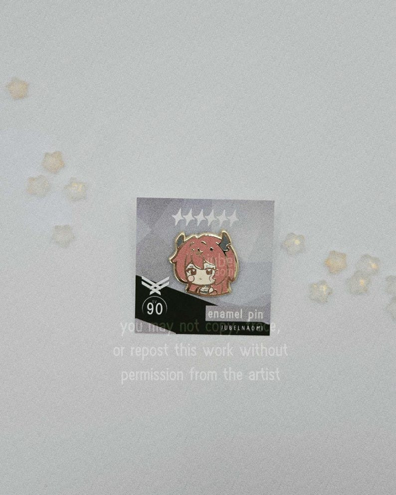 May include: An enamel pin featuring a cartoon character with red hair and horns. The pin is on a card with text that reads "90" and "enamel pin". The card also includes text that says "you may not copy or repost this work without permission from the artist."