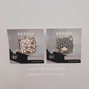 May include: Two enamel pins featuring anime-style characters with gold accents. One pin has a light-colored character, the other a gray character. Each pin is on a gray card with text that reads "enamel pin" and "JUBELNAOMI".