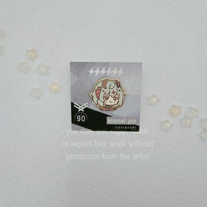 May include: An enamel pin featuring a cartoon character with red and gray hair, set against a gray and white background. The pin is on a card with text that reads "enamel pin" and "90". The card also has text that says "You may not copy, trace, or repost this work without permission from the artist."