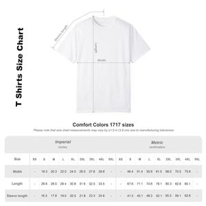 May include: A white t-shirt size chart for Comfort Colors 1717. The graphic displays a t-shirt with lines indicating sleeve length, body length, and width. A table provides measurements in inches for sizes S through 4XL, noting a 1.5 inch tolerance.