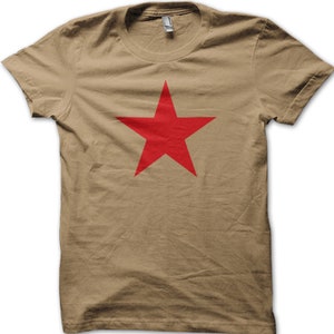 May include: A khaki t-shirt with a large red five-pointed star printed on the front.