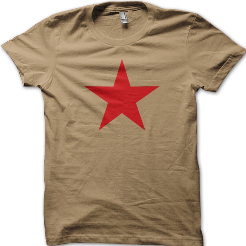 May include: A khaki t-shirt with a large red five-pointed star printed on the front.