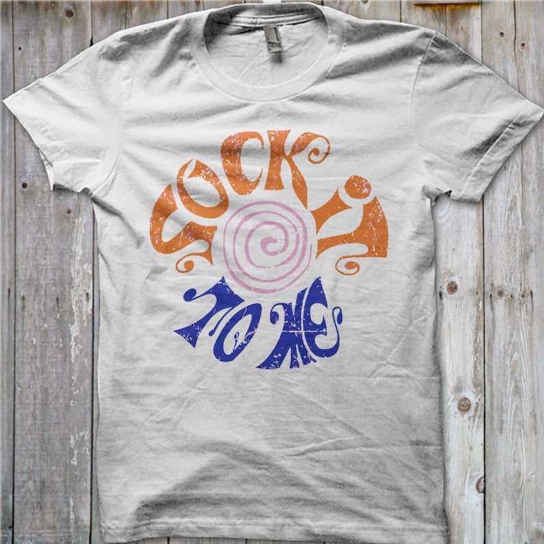 K&ouml;nnte beinhalten: Wei&szlig;es T-Shirt mit einem Vintage-Grafikdesign, das "Rock to Me" in orangefarbenen und blauen Buchstaben mit einem rosa und wei&szlig;en Wirbel in der Mitte sagt.
