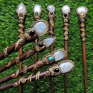 May include: Set of six wooden hair sticks with decorative carvings and moonstone accents. Each stick features a different coloured gemstone at the top.