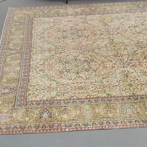 May include: A cream-colored rug with a floral pattern and a multi-colored border. The rug has a traditional Persian design.