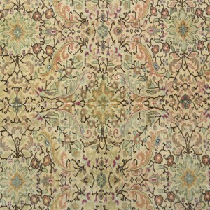 May include: A beige rug with a detailed floral pattern in shades of brown, pink, and blue. The rug has a symmetrical design with a central medallion.