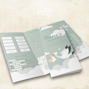May include: A green and white baby shower game booklet with a stork carrying a baby. The booklet includes games like "Baby Match Up", "Emoji Dictionary", "Name the Tune", and "Scrambled".