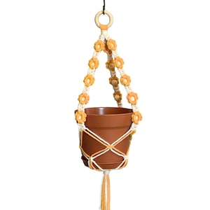 A plant hanger with beautiful floral details that come in a variety of colors to choose from.