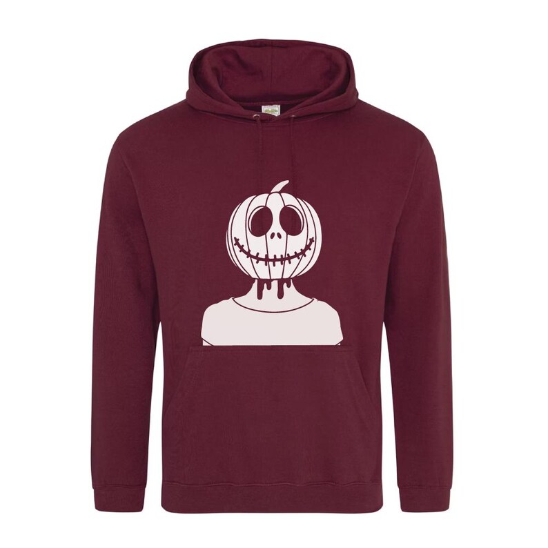 Op de afbeelding: Een bordeauxrode hoodie met een witte afbeelding van een pompoen met een gezicht. De pompoen heeft een gestikte mond en druipende ogen.